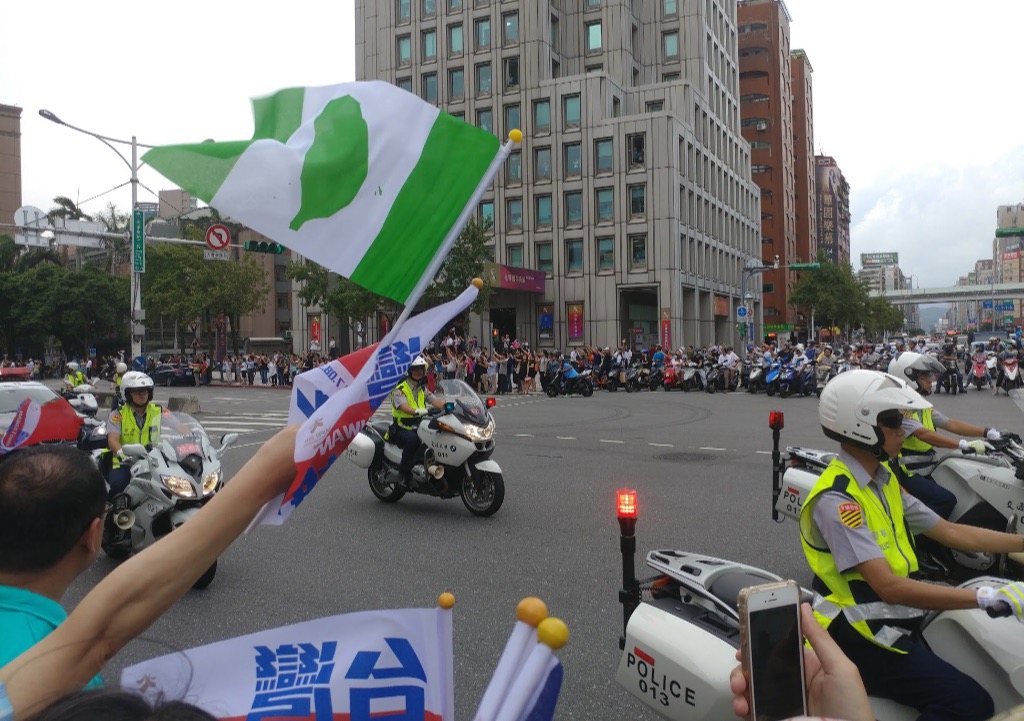 忠孝東路與新生南路交叉口，警方為遊行開道，民眾揮舞台灣旗加油。