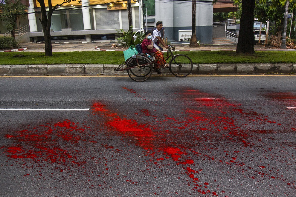 緬甸挺民主示威者6日在第一大城仰光的道路上噴灑紅漆，控訴軍政府手上沾滿鮮血。 圖：達志影像／美聯社