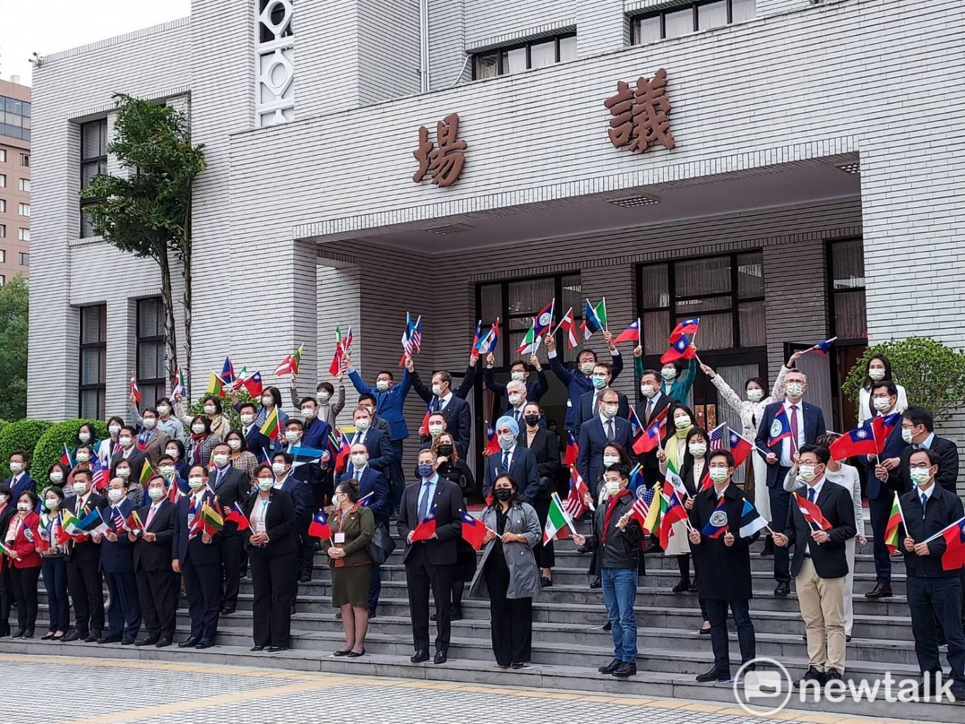 外賓與朝野立委揮舞旗幟紀念。 圖：陳佩君／攝