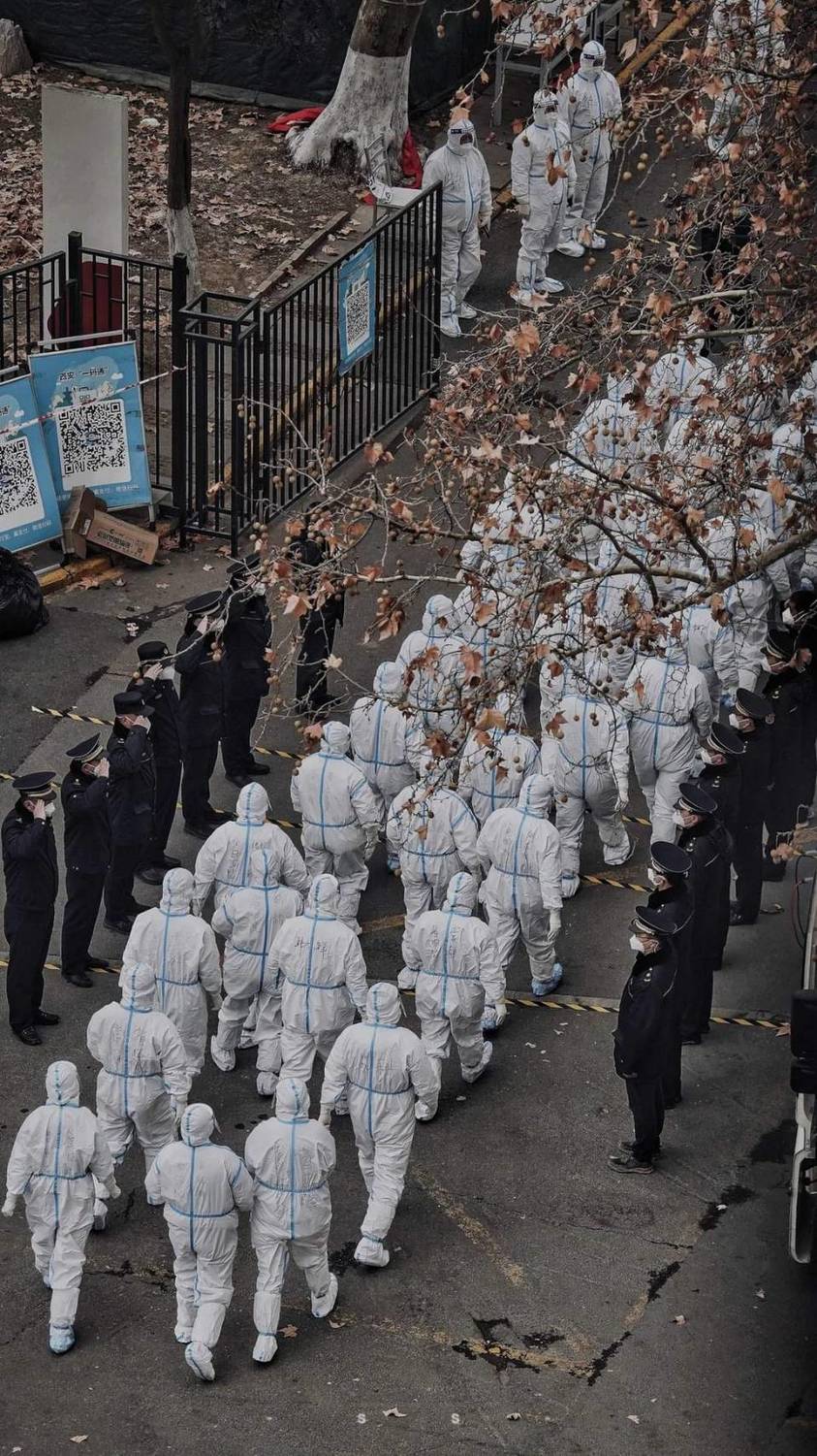 中國大批防疫人員緊急進駐西安，執行封鎖令的警員在兩旁列隊舉手致敬。 圖 : 翻攝自騰訊網