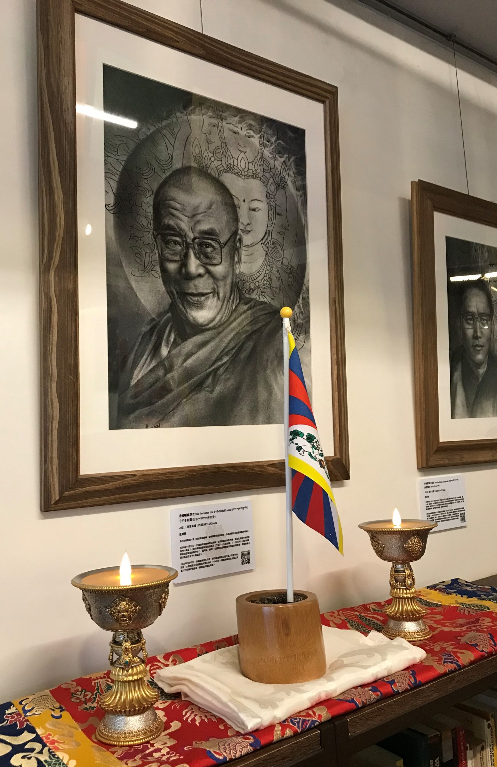 西藏人權捍衛者肖像展於左轉有書展出「達賴喇嘛尊者與千手千眼觀音」畫作。圖/吳佩儒拍攝