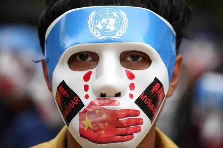 緬甸民眾戴著「反中國噤聲聯合國」面具，進行遊行。圖/取自推特帳號sfys000